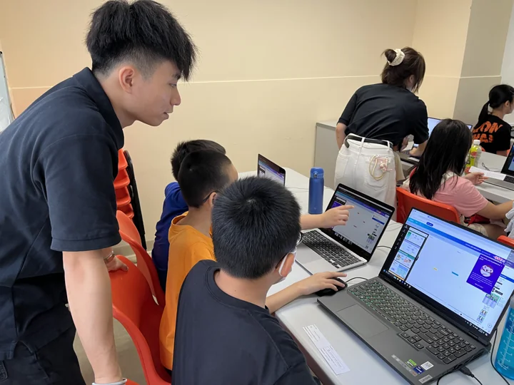 A coach helping a student with a programming project