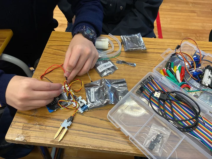 Hands assembling an electronic circuit at a workbench