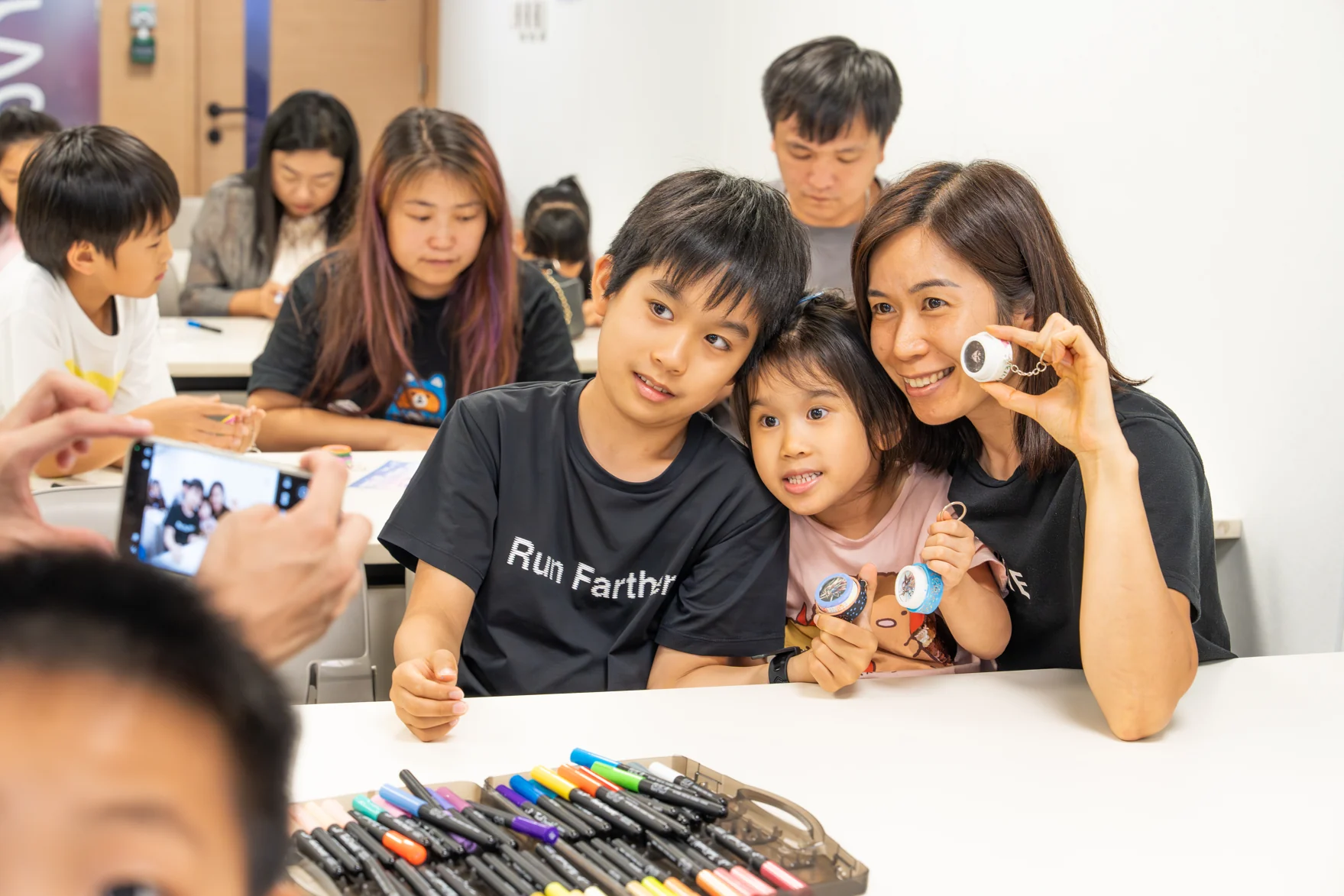 Children and adults learning together around a table of colourful electronics