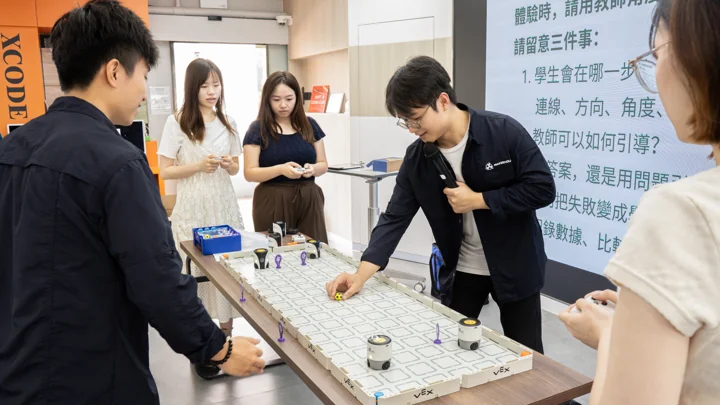Teachers exploring VEX AIM robots and programming together during the workshop